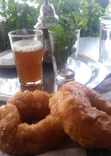 Golden Brown Moroccan Donut Beside Teapot And Glass Of Tea